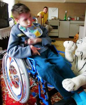 Behinderter Junge in Bosnien mit seinem neuen Rollstuhl